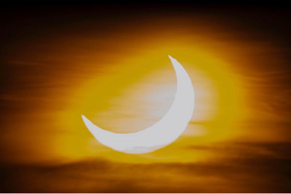 A sun setting with the moon in the background.