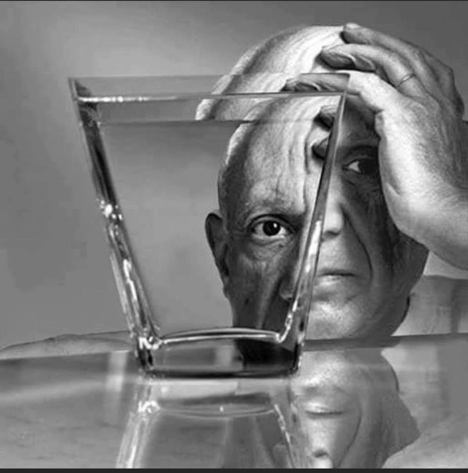 A man sitting at the table with his head in front of a glass.